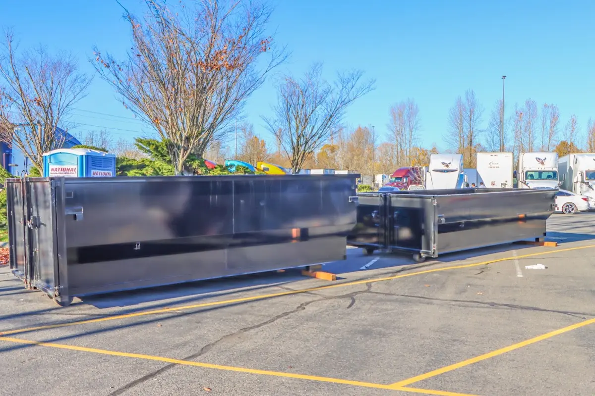 Professional dumpster rental service with roll-off container on residential driveway in Arab